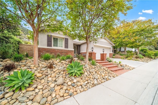 26544 Mahonia Way, Murrieta, CA 92562 - view of front of house with stucco siding, driveway, an attached garage, and brick siding