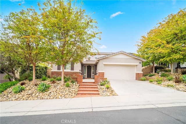 26544 Mahonia Way, Murrieta, CA 92562 - view of front of home with an attached garage, concrete driveway, stucco siding, and brick siding