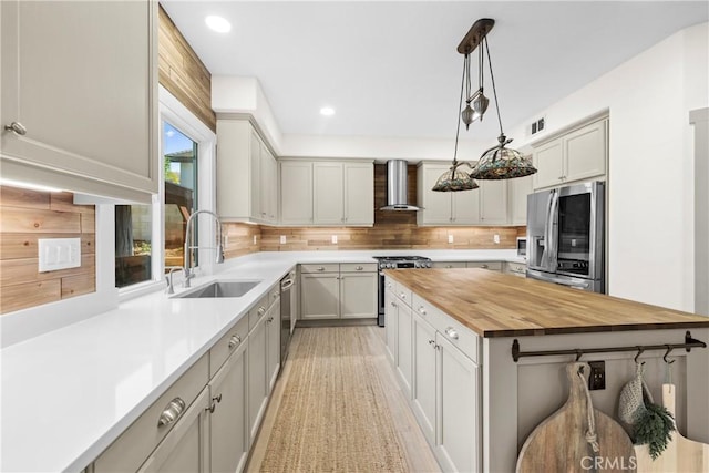 26544 Mahonia Way, Murrieta, CA 92562 - kitchen with appliances with stainless steel finishes, wood counters, wall chimney exhaust hood, decorative backsplash, and pendant lighting
