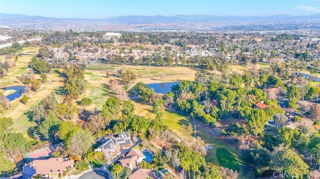 drone / aerial view featuring a water and mountain view, golf course view, and a residential view