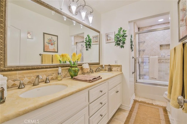 bathroom with tile patterned flooring, a sink, enclosed tub / shower combo, and double vanity