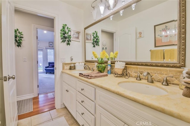 full bathroom with double vanity, a sink, decorative backsplash, and tile patterned floors