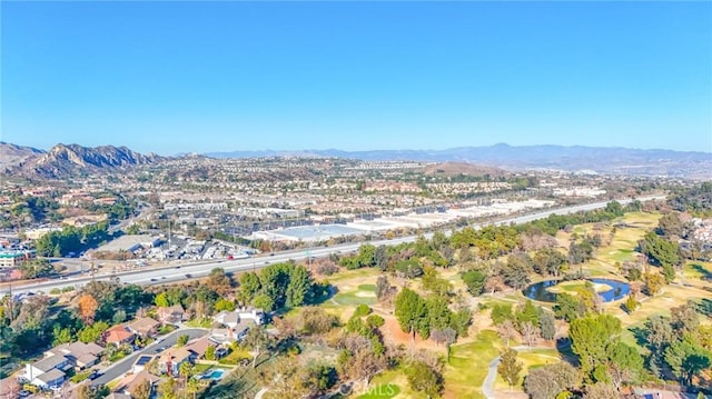 drone / aerial view with a water and mountain view, view of golf course, and a residential view