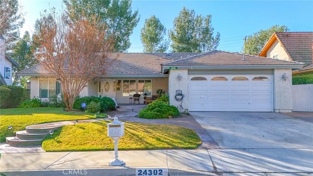 ranch-style house featuring a garage, stucco siding, driveway, and a front lawn
