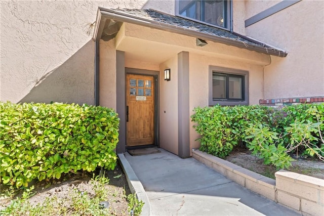 entrance to property featuring stucco siding
