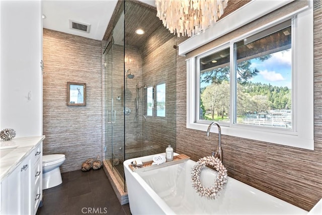 full bath featuring vanity, visible vents, toilet, a freestanding bath, and a stall shower