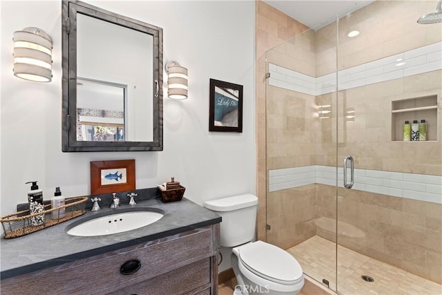 full bathroom featuring vanity, a stall shower, and toilet