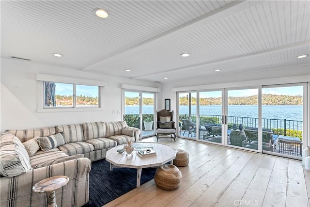 living area with beam ceiling, wood-type flooring, recessed lighting, a water view, and visible vents