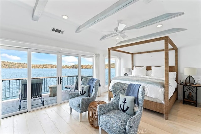bedroom with visible vents, wood finished floors, beam ceiling, access to exterior, and multiple windows