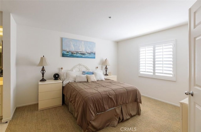 bedroom featuring light colored carpet and baseboards