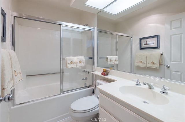 full bath featuring vanity, bath / shower combo with glass door, and toilet