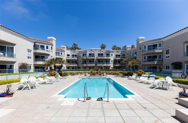 pool featuring fence, a residential view, and a patio area