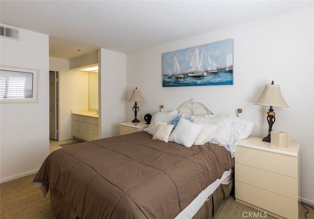 bedroom with visible vents, connected bathroom, baseboards, and light colored carpet