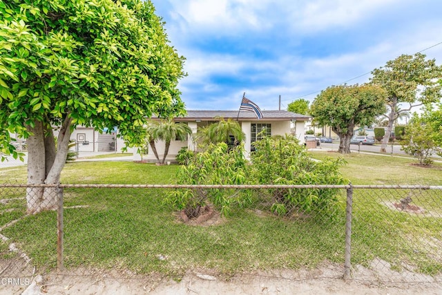 view of front of property featuring a front lawn, stucco siding, and fence