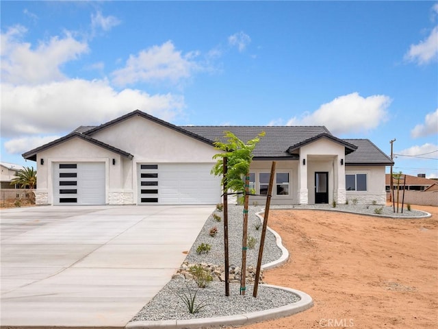 view of front facade featuring a garage, stucco siding, driveway, and stone siding