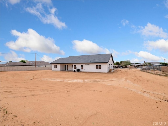 back of house with fence and stucco siding