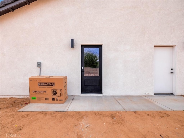 property entrance featuring stucco siding