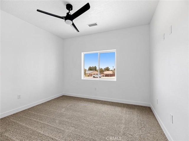 spare room with visible vents, carpet flooring, baseboards, and ceiling fan