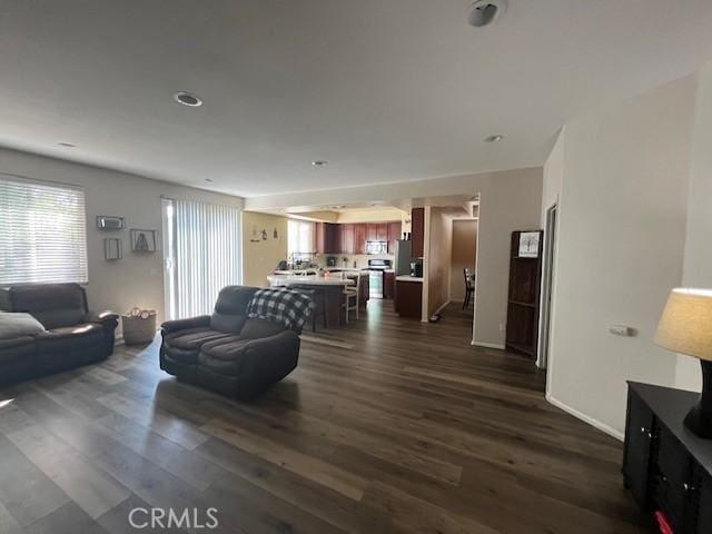 living area featuring baseboards and dark wood finished floors