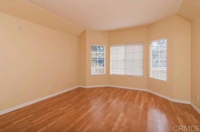 unfurnished room with baseboards and wood finished floors