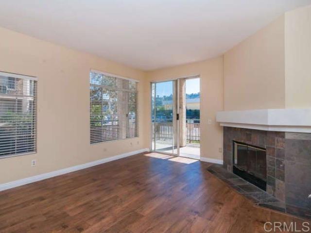 unfurnished living room featuring baseboards, wood finished floors, and a tile fireplace