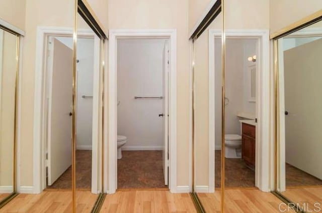 bathroom featuring vanity, toilet, and wood finished floors