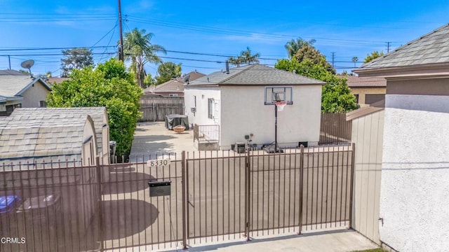 view of patio with a gate, an outbuilding, a storage unit, and fence private yard