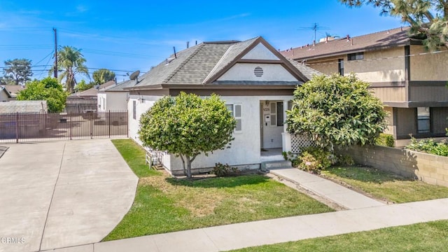 view of front of house featuring fence, a front yard, and stucco siding