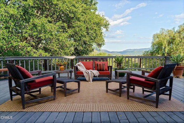 deck with an outdoor living space and a mountain view