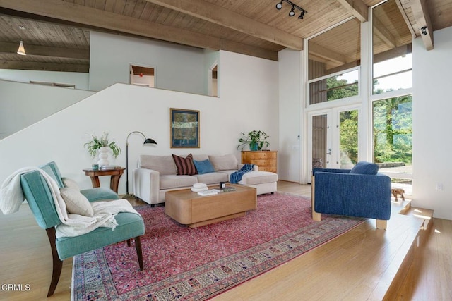 living area featuring wooden ceiling, high vaulted ceiling, beam ceiling, track lighting, and wood finished floors