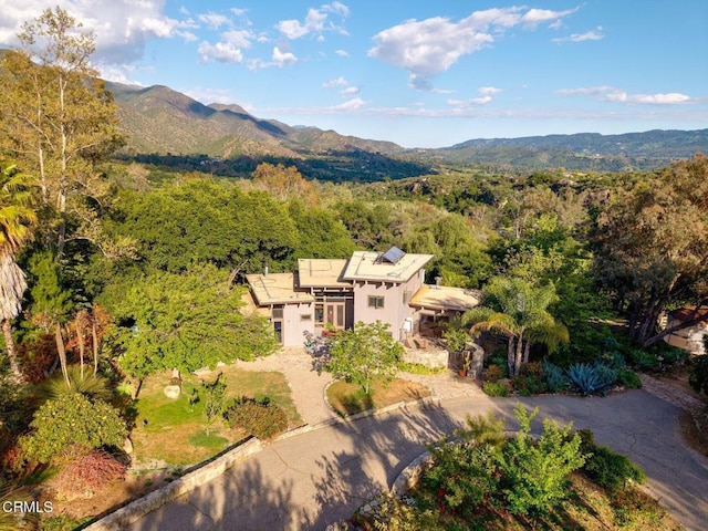 view of subject property with a heavily wooded area and mountains