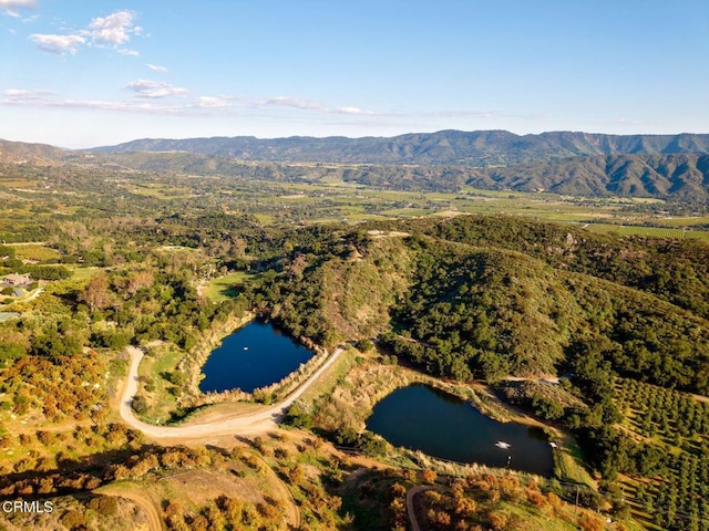 aerial view of property and surrounding area featuring a water and mountain view