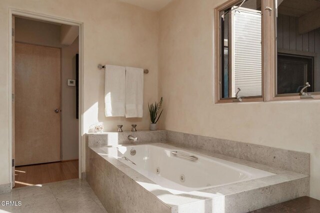 full bathroom featuring a tub with jets and tile patterned floors