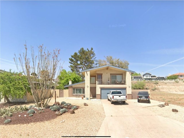 view of front facade featuring an attached garage, stucco siding, concrete driveway, and a balcony