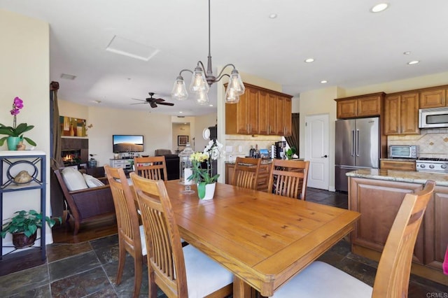 944 Rainbow Crest Rd, Fallbrook, CA 92028 - dining room with stone tile flooring, recessed lighting, ceiling fan, and a warm lit fireplace