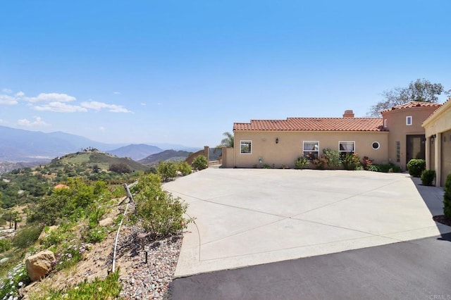 944 Rainbow Crest Rd, Fallbrook, CA 92028 - view of front facade featuring a tile roof, a mountain view, a chimney, stucco siding, and concrete driveway