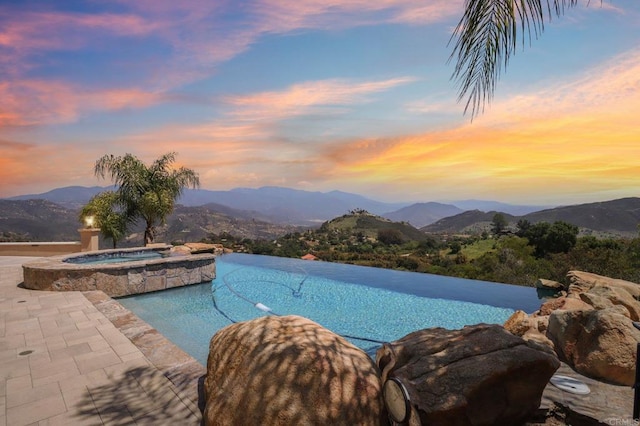 944 Rainbow Crest Rd, Fallbrook, CA 92028 - pool at dusk with a mountain view, a pool with connected hot tub, and a patio area