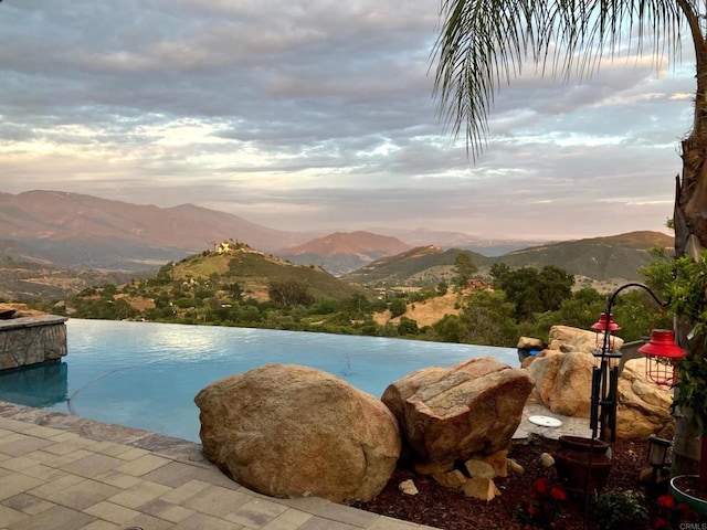 944 Rainbow Crest Rd, Fallbrook, CA 92028 - pool at dusk featuring a mountain view and an infinity pool