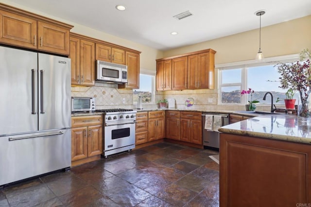 944 Rainbow Crest Rd, Fallbrook, CA 92028 - kitchen featuring premium appliances, brown cabinetry, light stone countertops, and recessed lighting