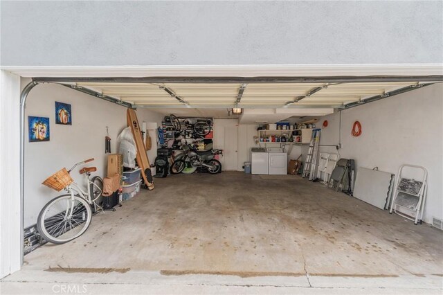 garage with washer and clothes dryer and a garage door opener