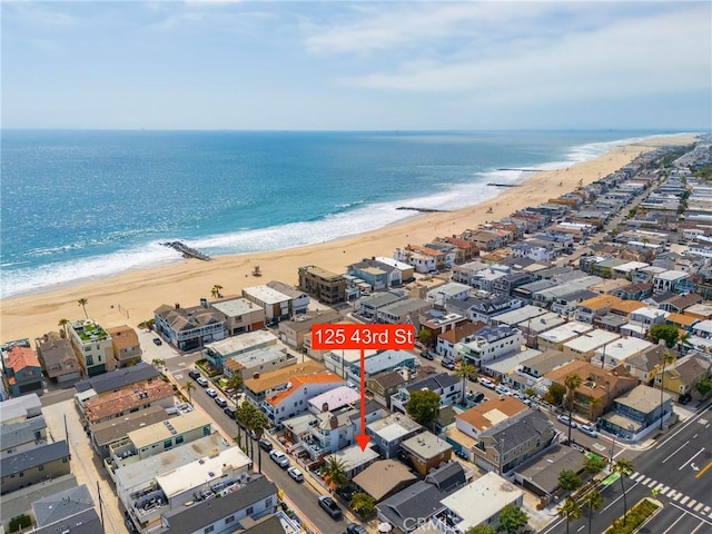 aerial view of property's location featuring waterfront with a beach