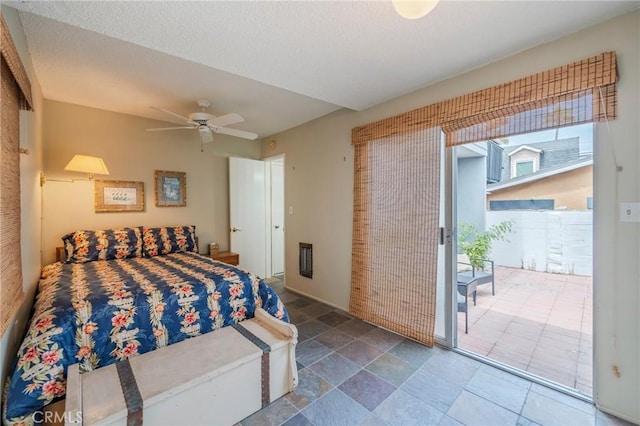 bedroom with access to exterior, stone finish flooring, and a ceiling fan