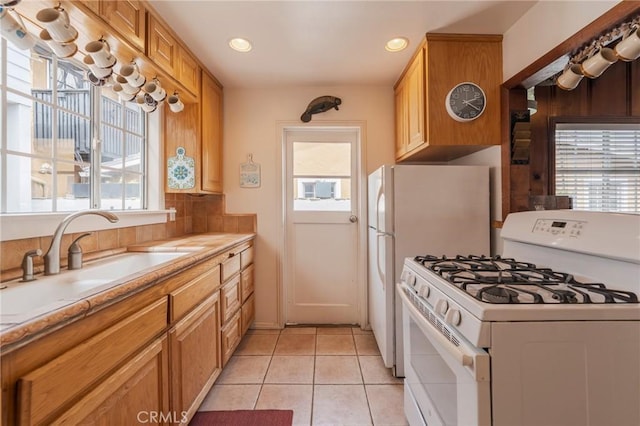 kitchen featuring white appliances, healthy amount of natural light, a sink, and recessed lighting