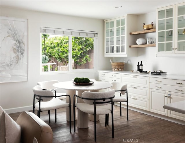 dining room with dark wood-style flooring, baseboards, and breakfast area