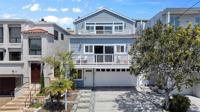 view of front of house with an attached garage, driveway, and a balcony