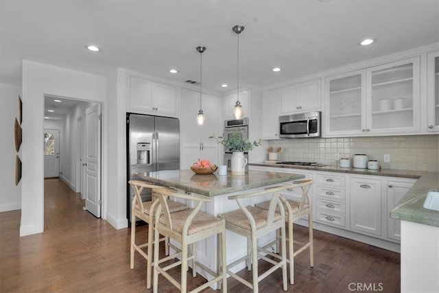 kitchen featuring visible vents, decorative backsplash, glass insert cabinets, white cabinetry, and stainless steel appliances