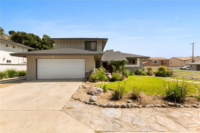1430 Caballo Ranch Rd, San Dimas, CA 91773 - view of front facade with a front yard, fence, concrete driveway, an attached garage, and stucco siding