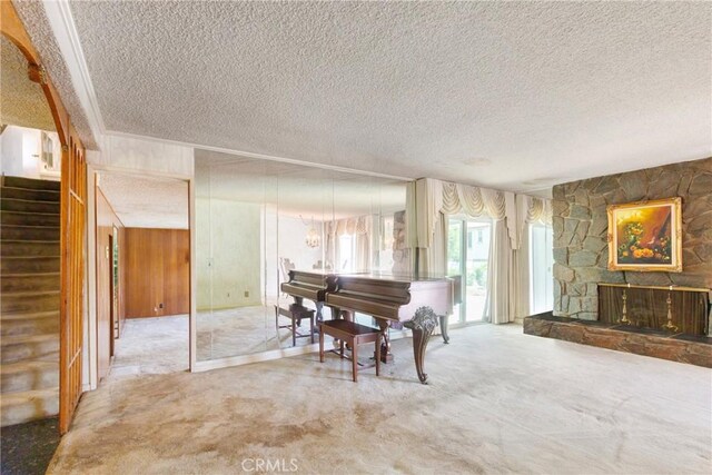 1430 Caballo Ranch Rd, San Dimas, CA 91773 - living area featuring a stone fireplace, a textured ceiling, stairway, wooden walls, and carpet