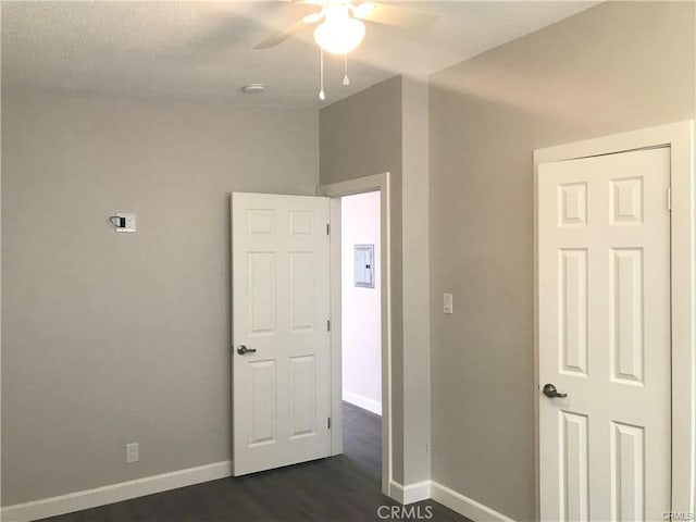 539 E 223rd St, Carson, CA 90745 - unfurnished bedroom with baseboards, dark wood-type flooring, electric panel, and a ceiling fan