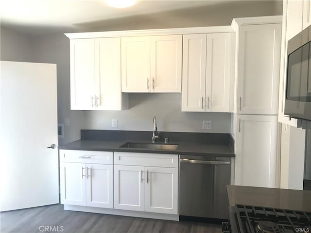 539 E 223rd St, Carson, CA 90745 - kitchen with stainless steel appliances, a sink, dark countertops, and white cabinetry